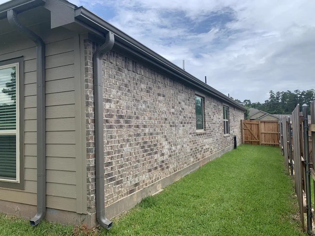 Long gutter run with coordinated downspouts on a brick home